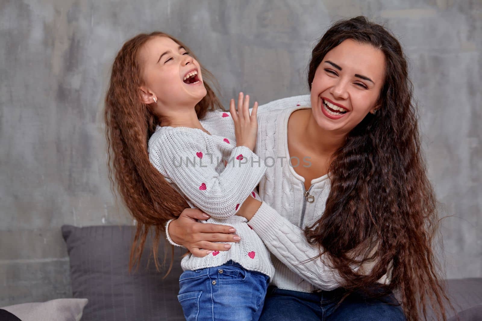 Emotions of a young beautiful mother and her little daughter who spend time together. They show love for each other