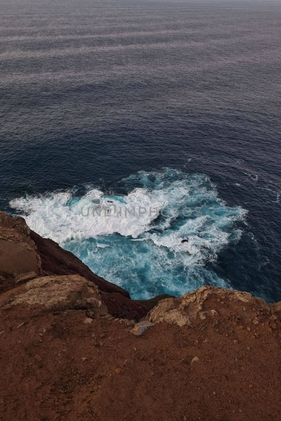 Beautiful turquoise water crashes against the rocks. Splashes of water