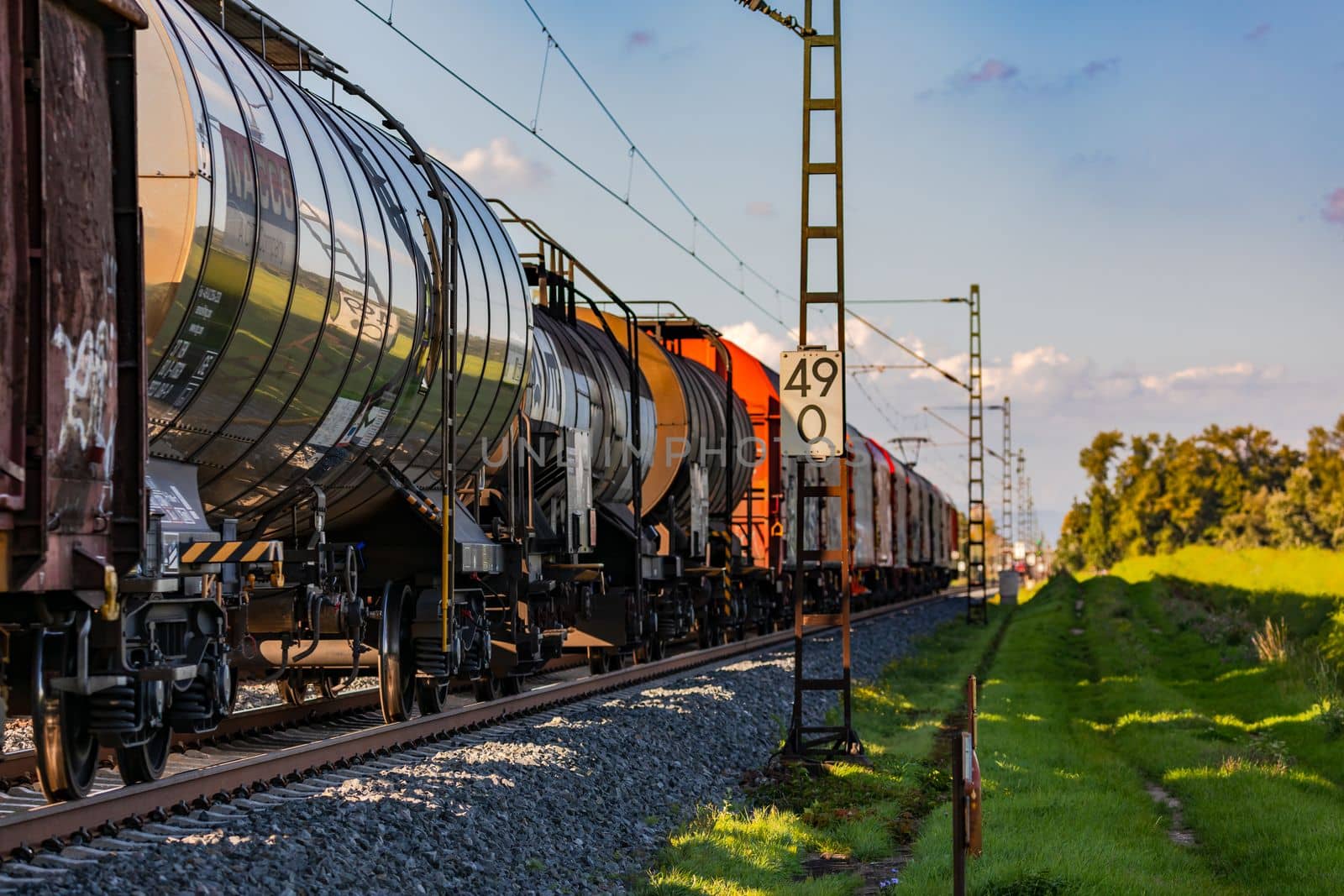 A freight train carrying goods and passing through a rural area, in autumn, Germany
