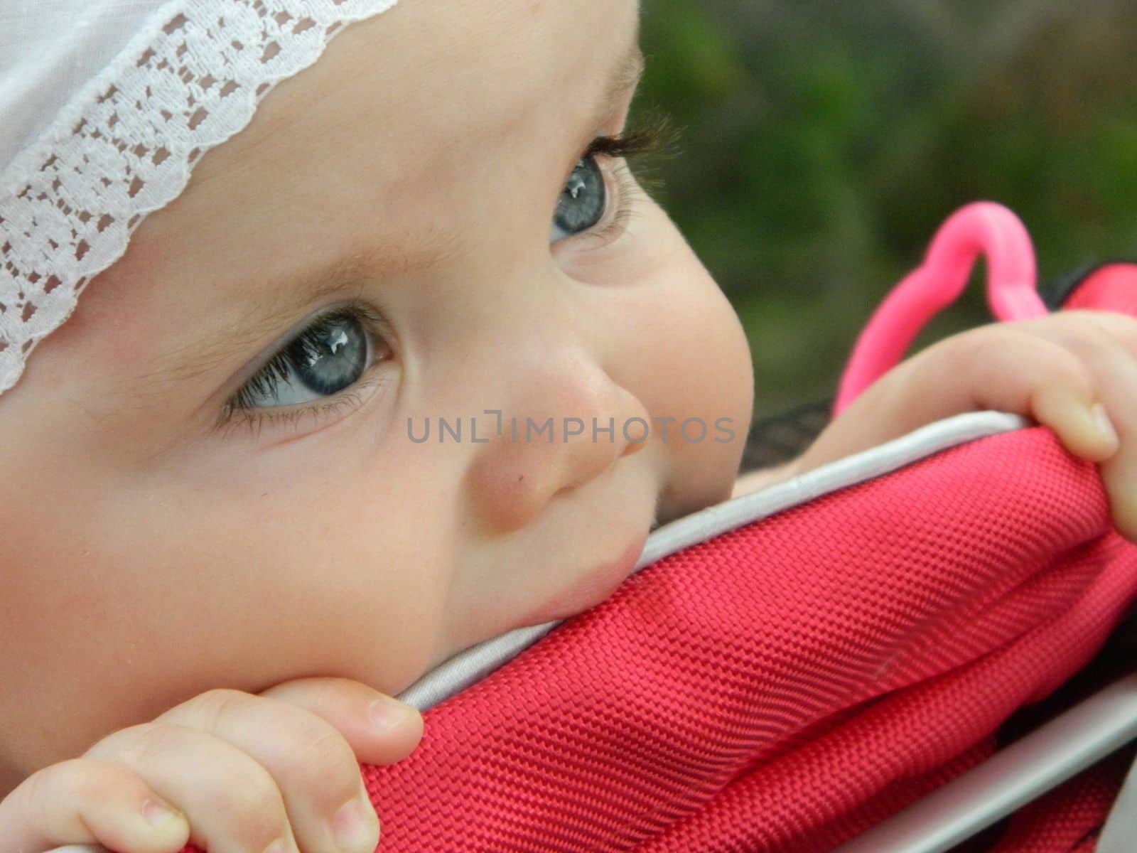 happy baby girl crawls and walks on the green lawn in the summer in the park. High quality photo