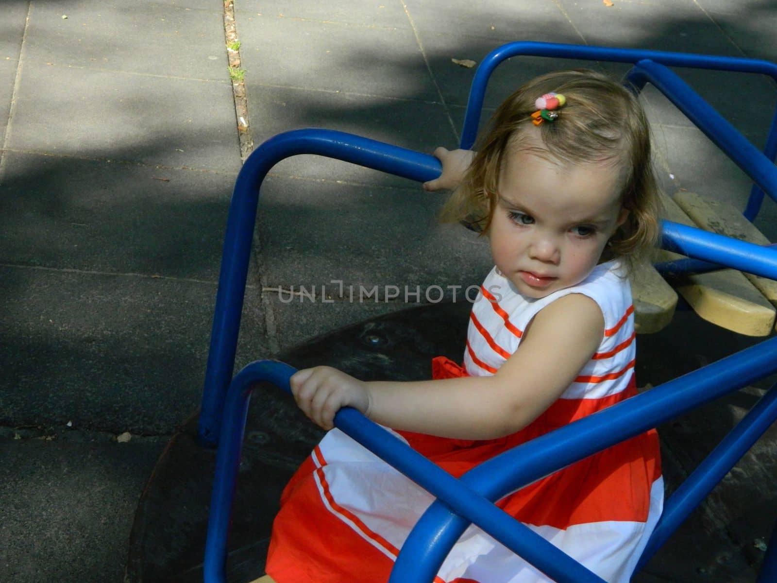 happy baby girl crawls and walks on the green lawn in the summer in the park. High quality photo