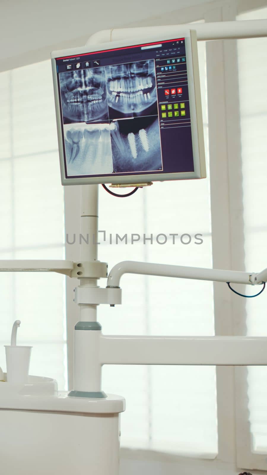 Pediatric dentist showing on monitor teeth x-ray reviewing it with mother and daughter. Doctor and nurse working together in modern stomatological clinic, explaining to old woman radiography of tooth