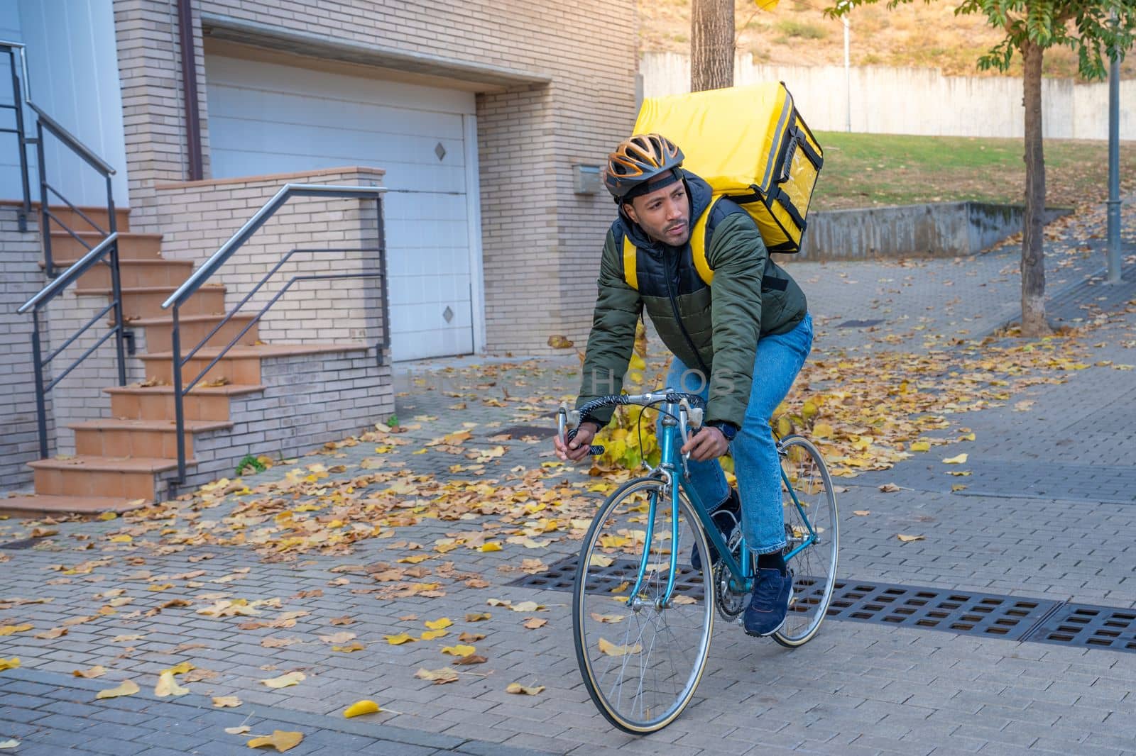 Delivery man riding bike delivering food and drink in town outdoors on stylish bicycle and backpack. by PaulCarr