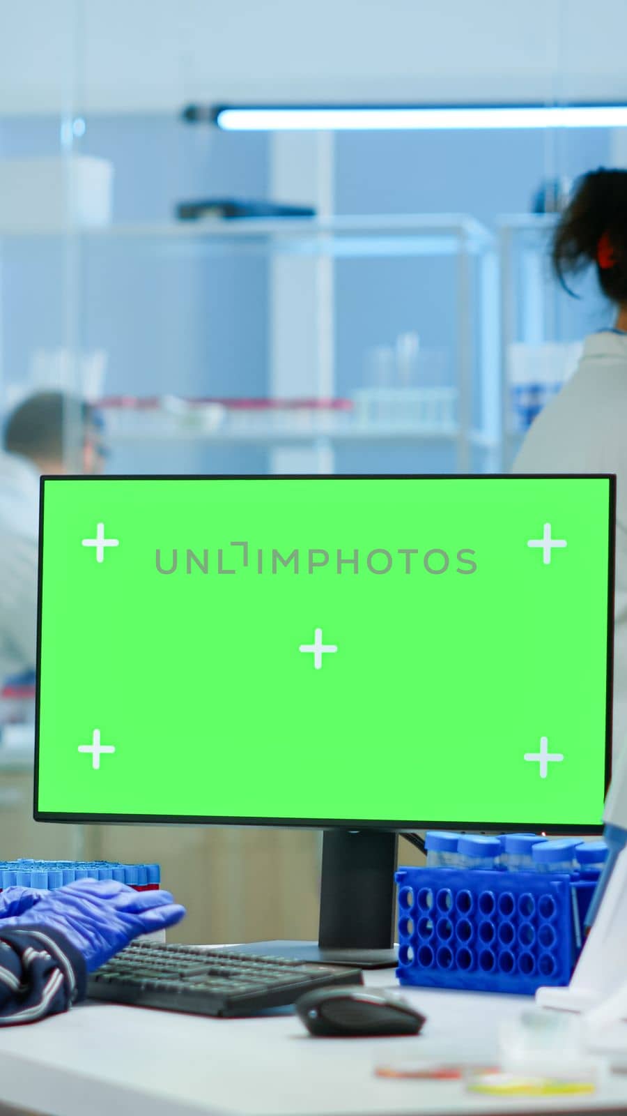 Medical research scientist working on pc with green screen mock up template in applied science laboratory. Engineers conducting experiments in background, examining vaccine evolution using high tech