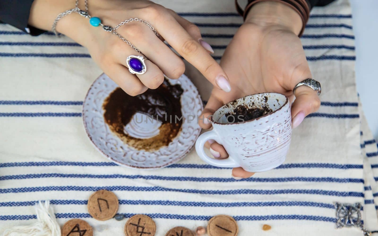 A fortune teller reads fortunes on coffee grounds. Selective focus. Woman.