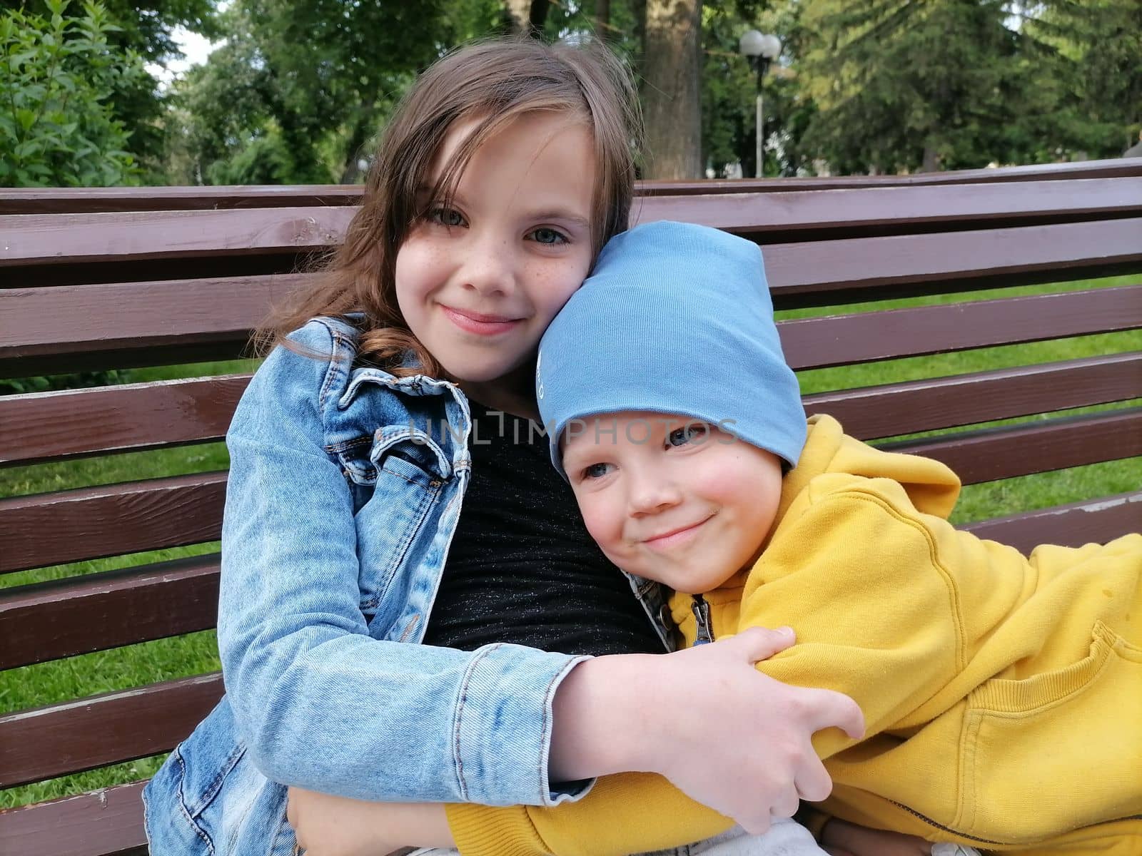 Portrait of adorable brother and sister smile and laugh together while sitting outdoors. happy lifestyle kids. High quality photo