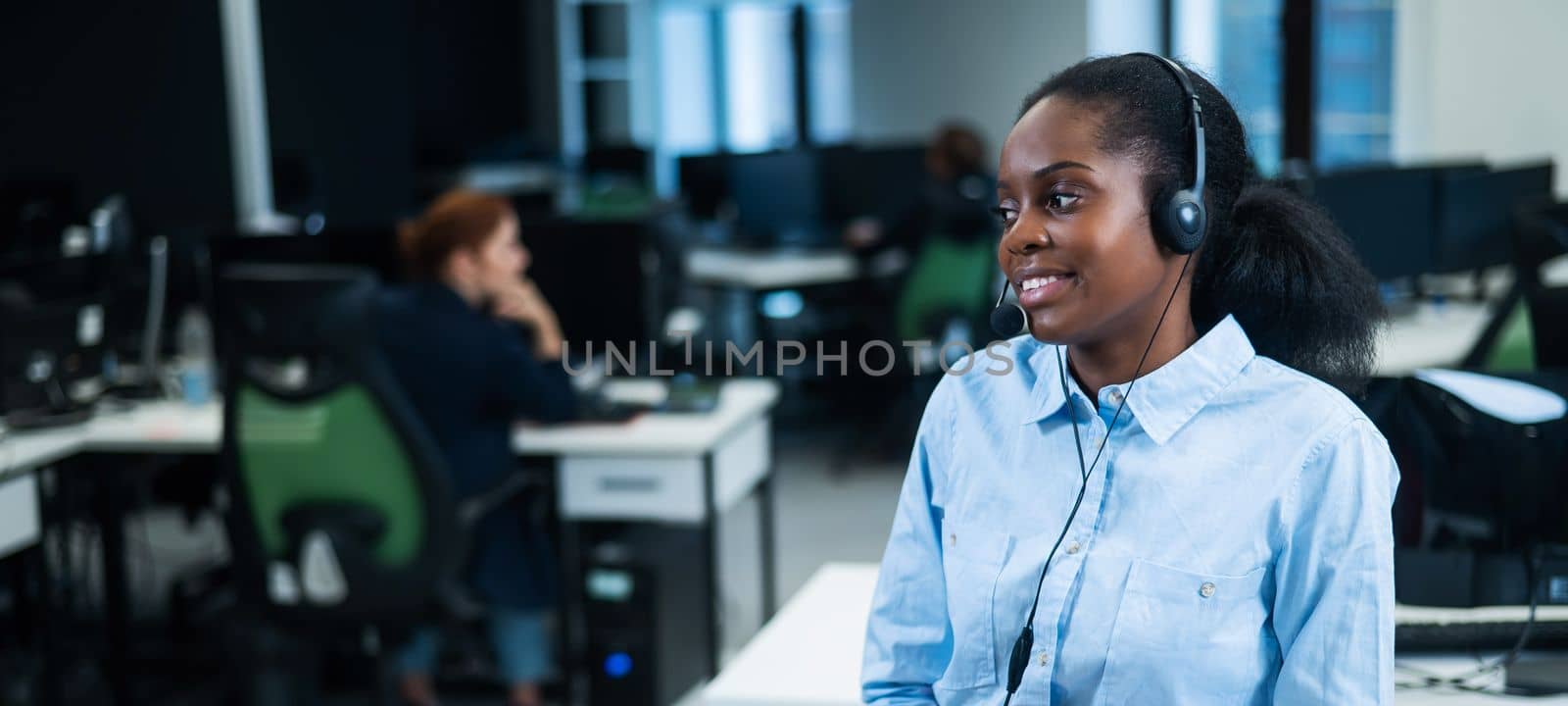 African young woman talking to a client on a headset. Female employee of the call center. by mrwed54