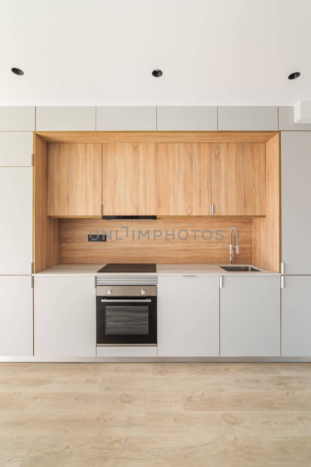 Simple empty modular kitchen area in modern apartment. Furniture minimalism with lots of cabinets, oven and stove for cooking delicious food