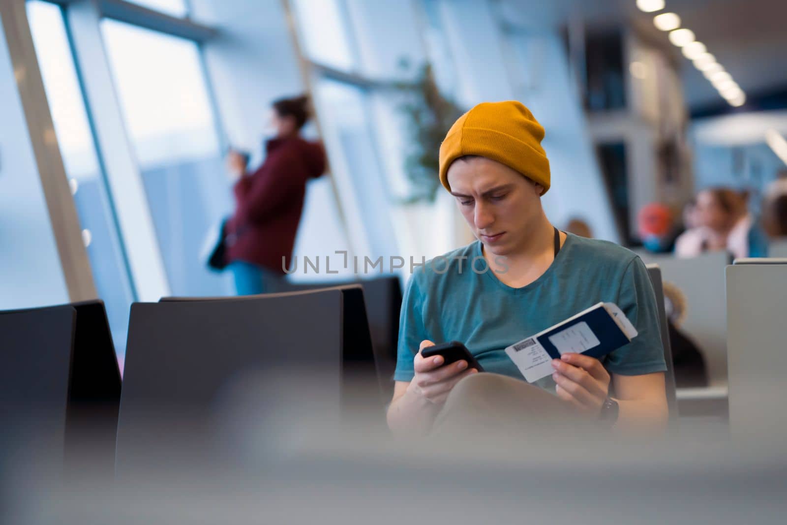 Man is sitting at the airport, waiting for flight. by africapink