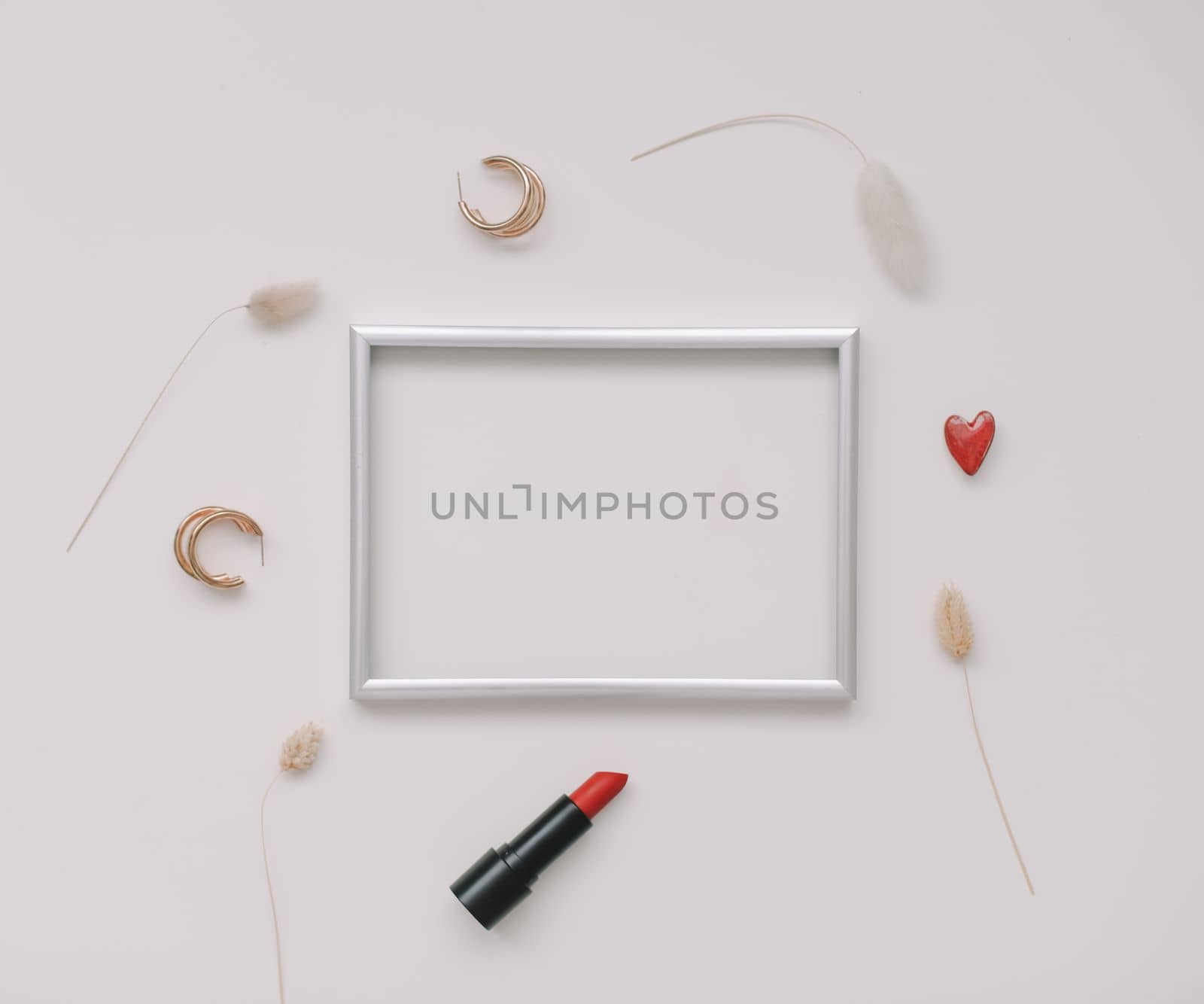 minimal fashion mockup with empty photo frame and red lipstick and women's accessories on white background. 