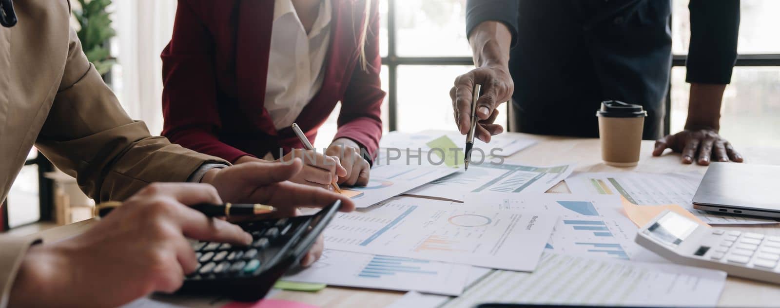 Business People Meeting using laptop computer,calculator,notebook,stock market chart paper for analysis Plans to improve quality next month. Conference Discussion Corporate Concept. by wichayada