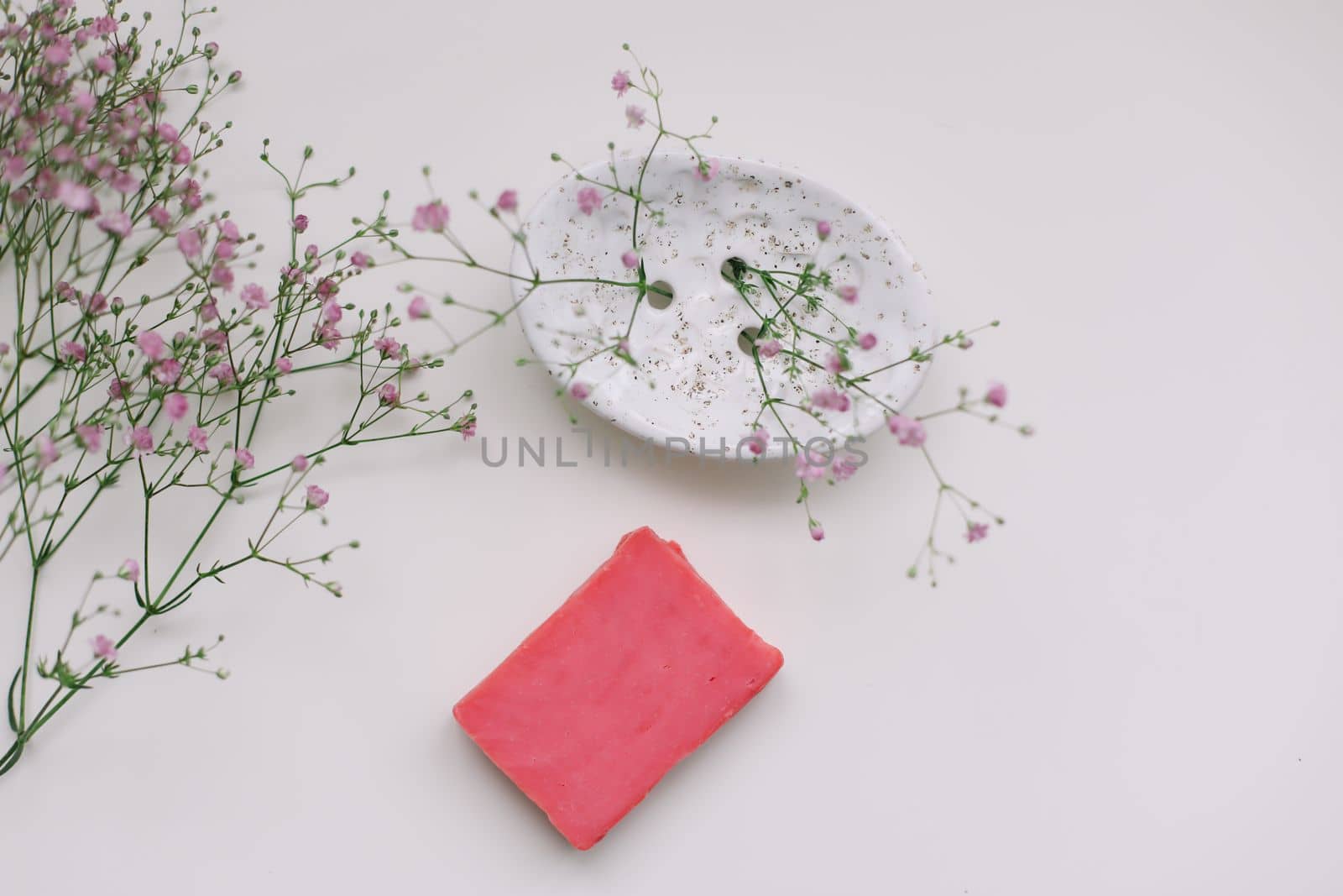 Natural handmade pink soap bar with ceramic soap dish and flowers, spa organic soap 