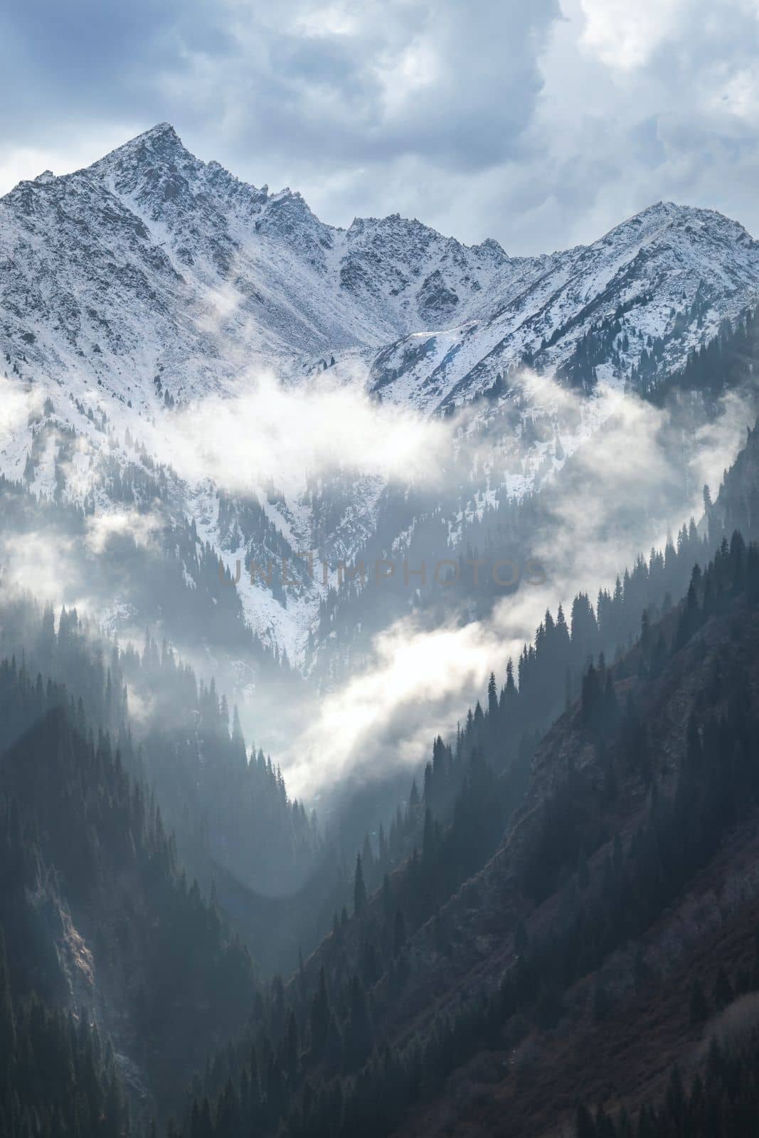 Snow Mountain with cloudy sky from Almaty region in Kazakhstan. Central asian picturesque landscape.