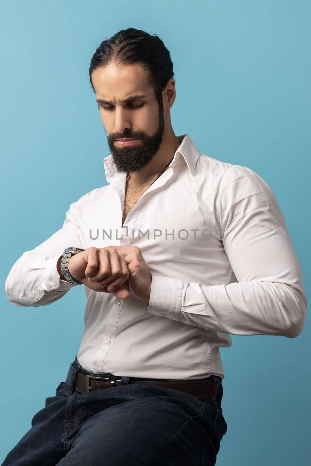 Man sitting and looking at his wristwatch, being harry to important event. by Khosro1