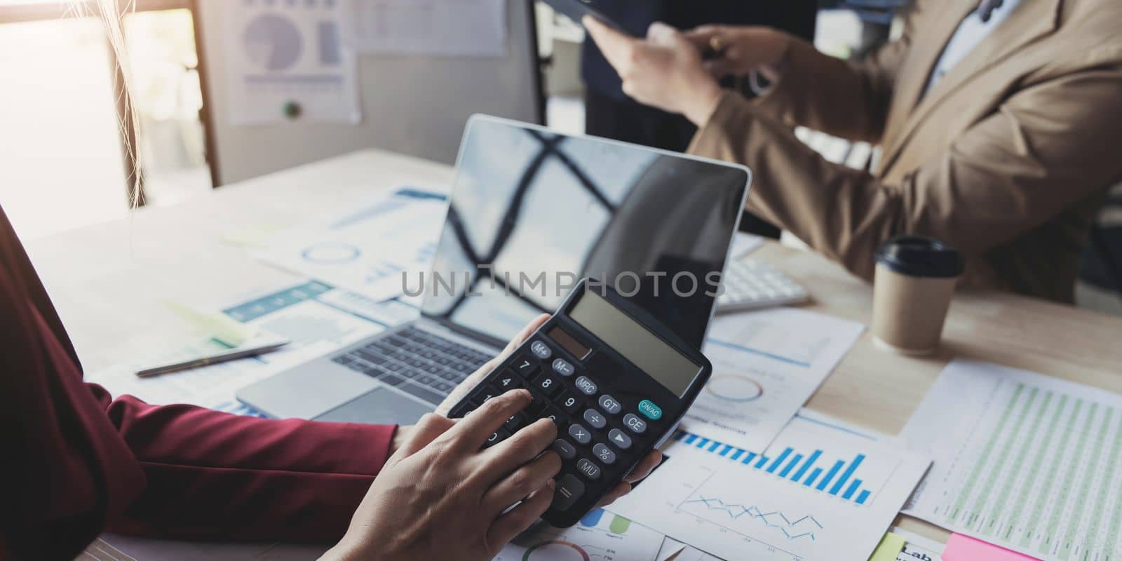 Business People Meeting using laptop computer,calculator,notebook,stock market chart paper for analysis Plans to improve quality next month. Conference Discussion Corporate Concept. by wichayada