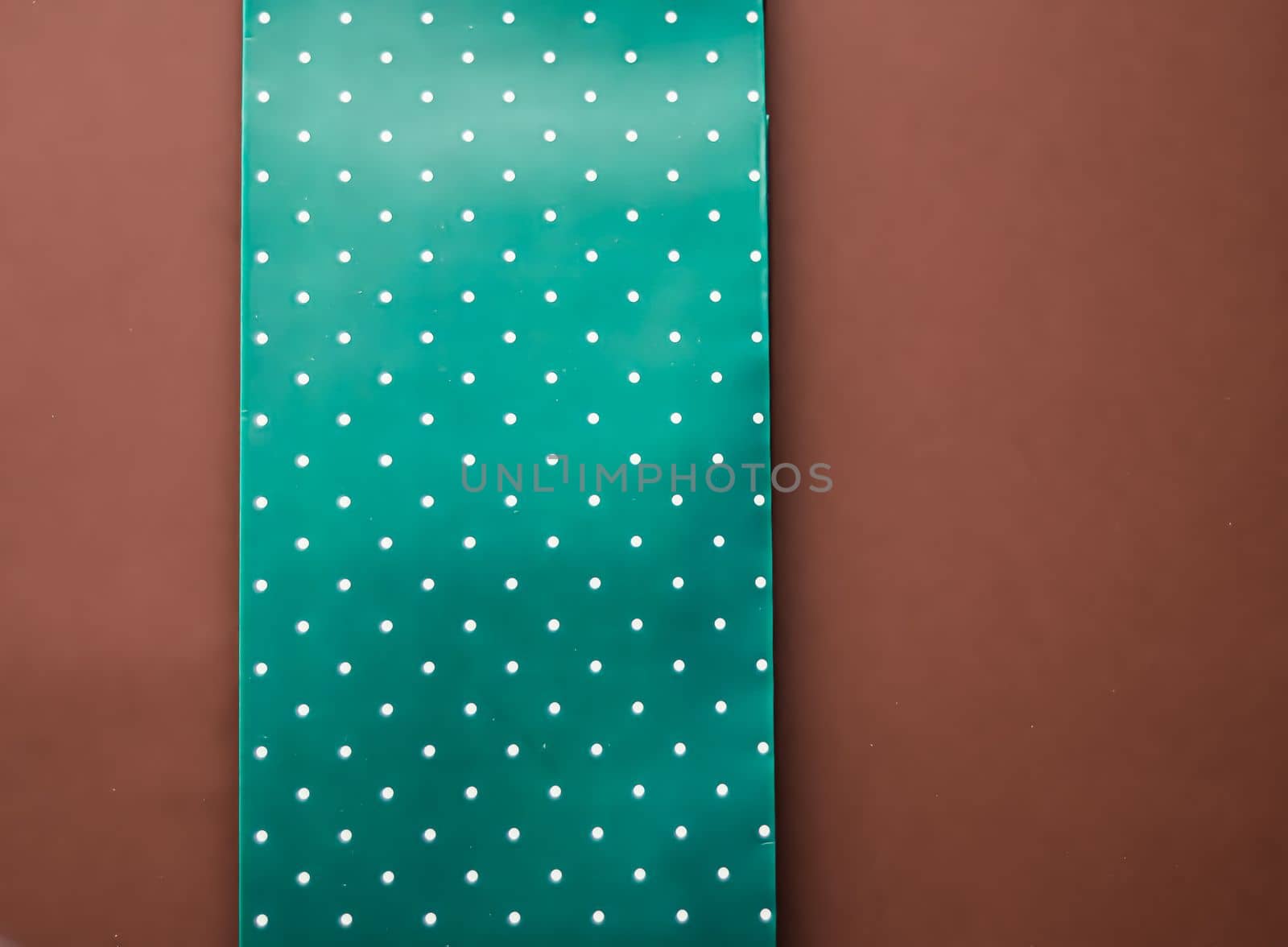 Abstract green polka dot background on brown backdrop.