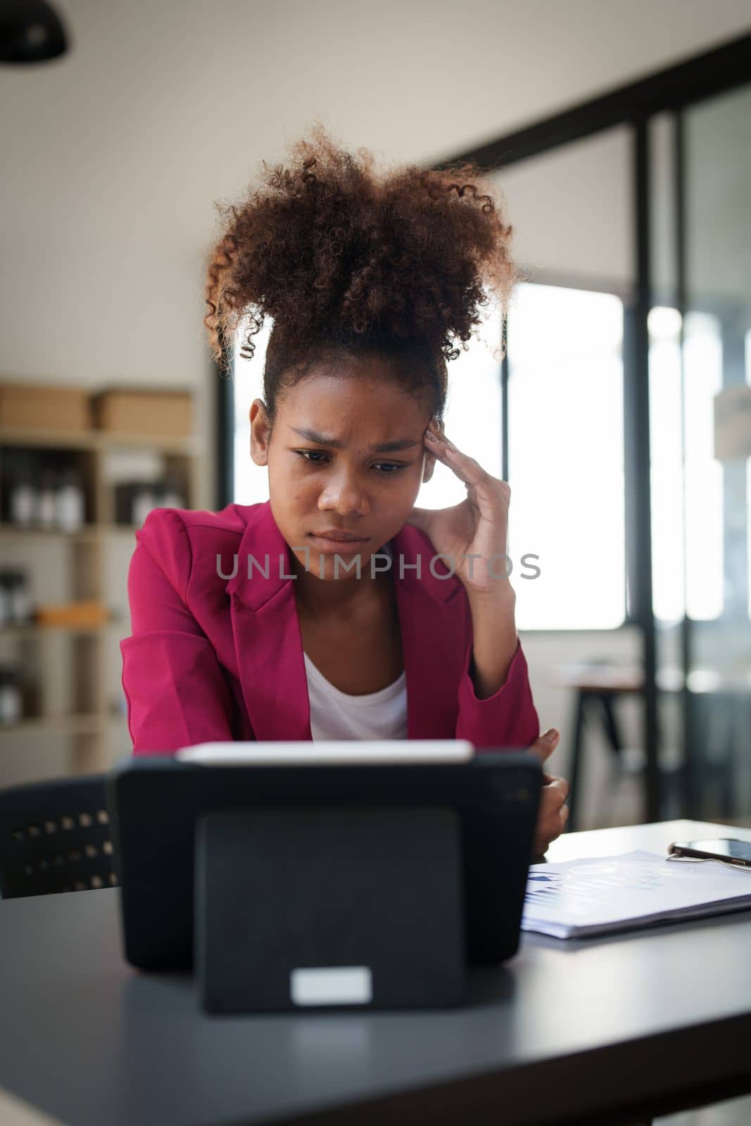 Portrait thoughtful confused young african american businesswoman looking at laptop. Stress while reading news, report or email. Online problem, finance mistake, troubleshooting.