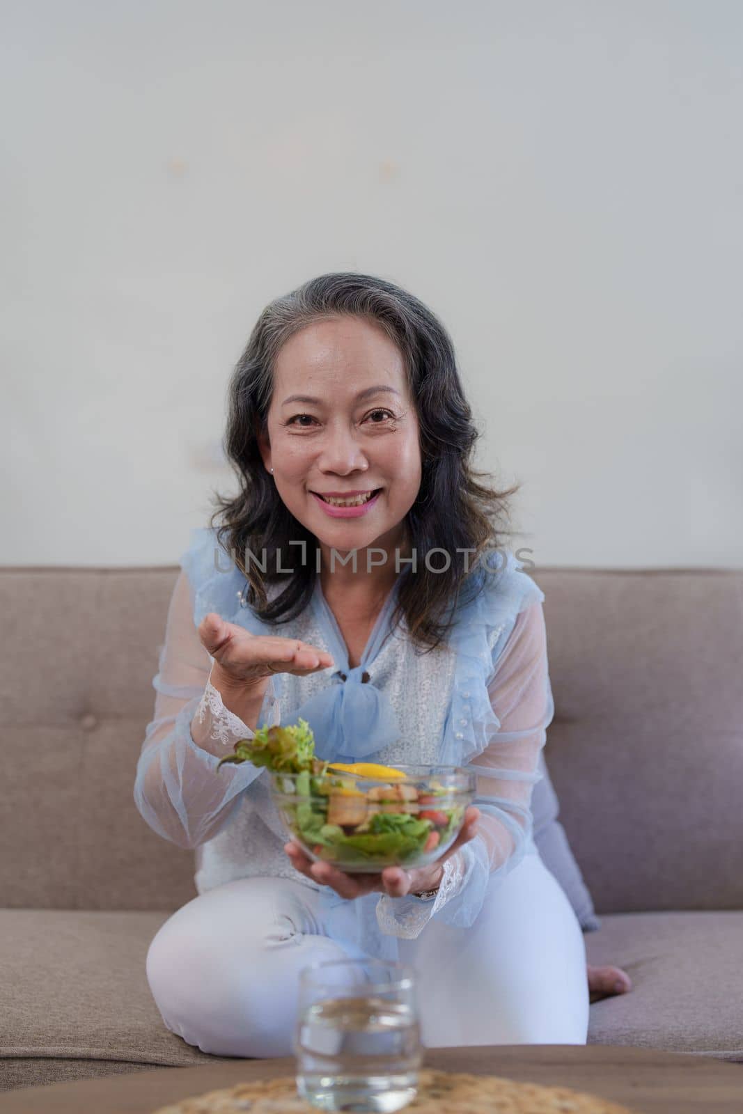 Happy old asian woman eating fresh green salad. Senior woman good healthy at home. Exercise and healthy diet concept by itchaznong