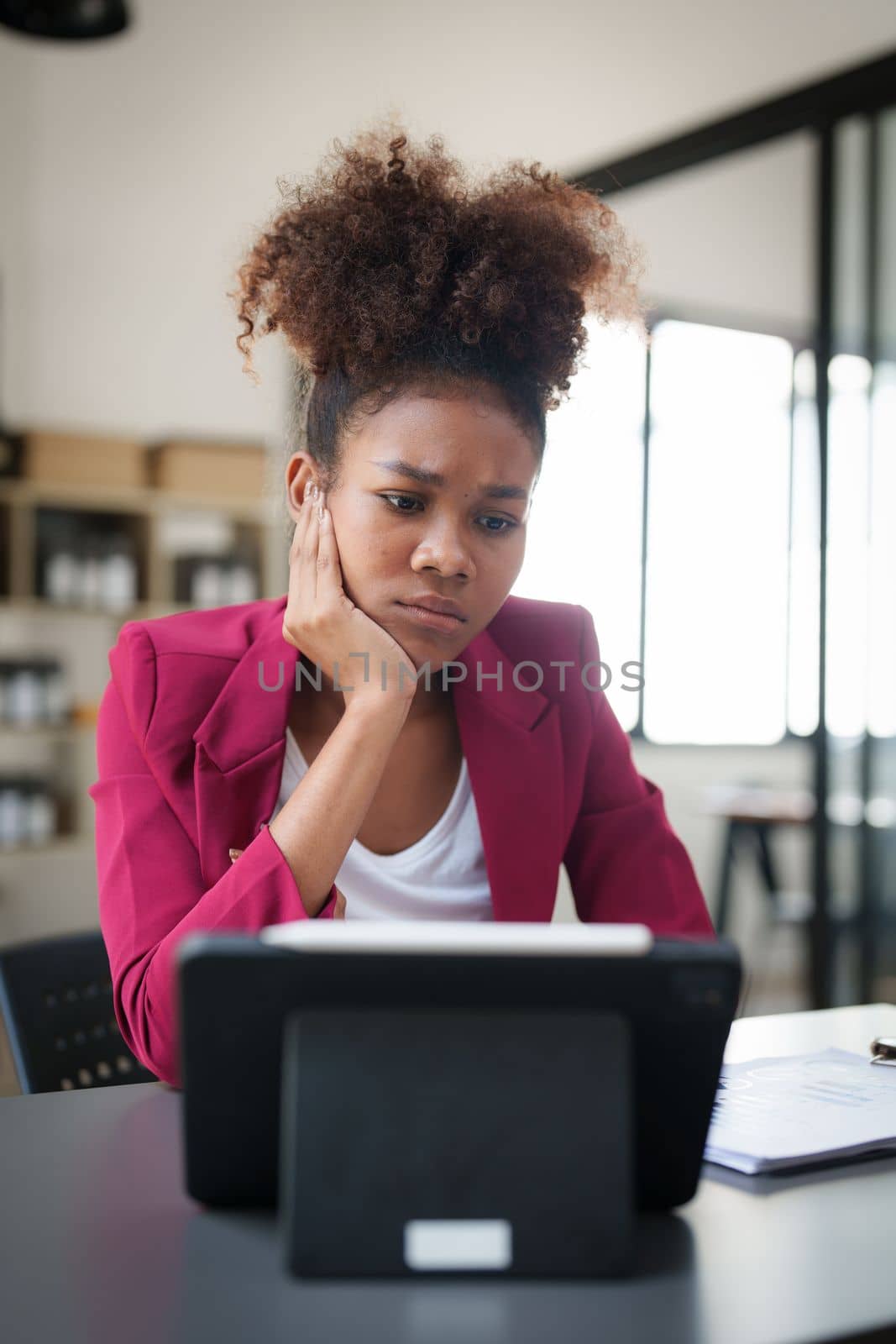 Portrait thoughtful confused young african american businesswoman looking at laptop. Stress while reading news, report or email. Online problem, finance mistake, troubleshooting.