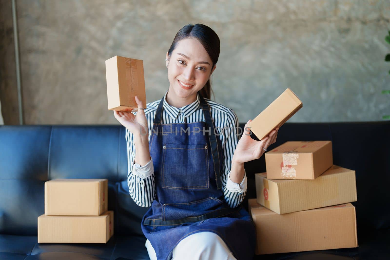 Starting small business entrepreneur of independent Asian female online seller packing products to send to customers and SME delivery concept.