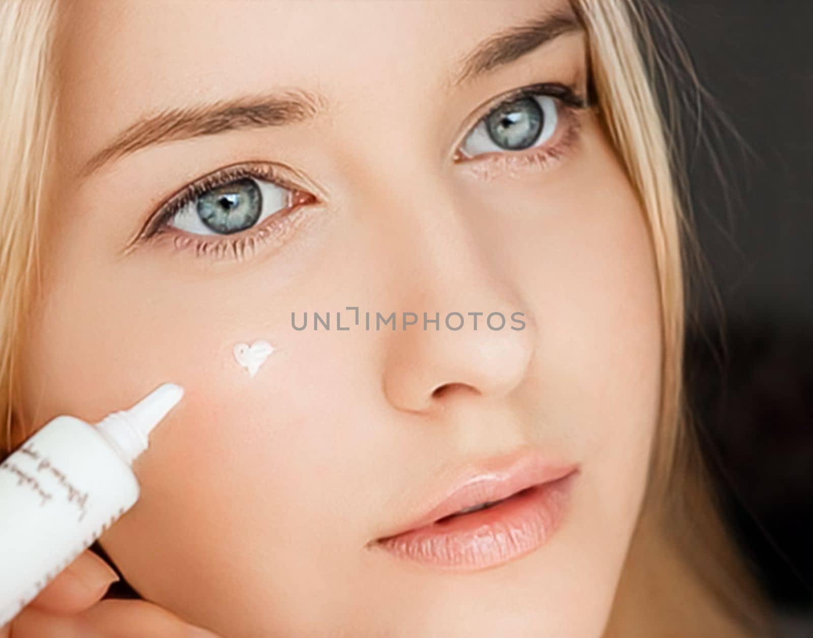 Beautiful woman applying skincare cream on her face.