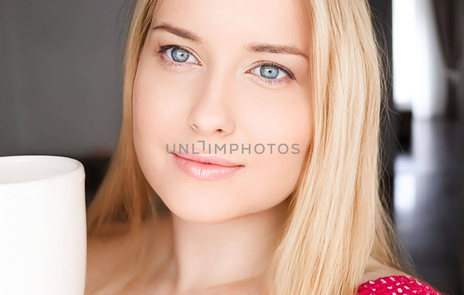 Beautiful blonde woman having a cup of tea in the morning at home.