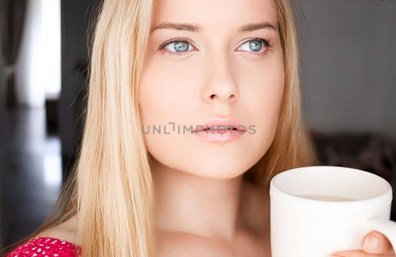 Beautiful blonde woman having a cup of tea in the morning at home.