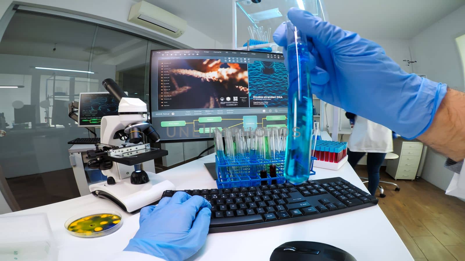 POV of doctor researcher holding an ampoule of coronavirus vaccine looking into test tube. Scientists examining vaccine evolution in medical lab using high tech chemistry tools for scientific research