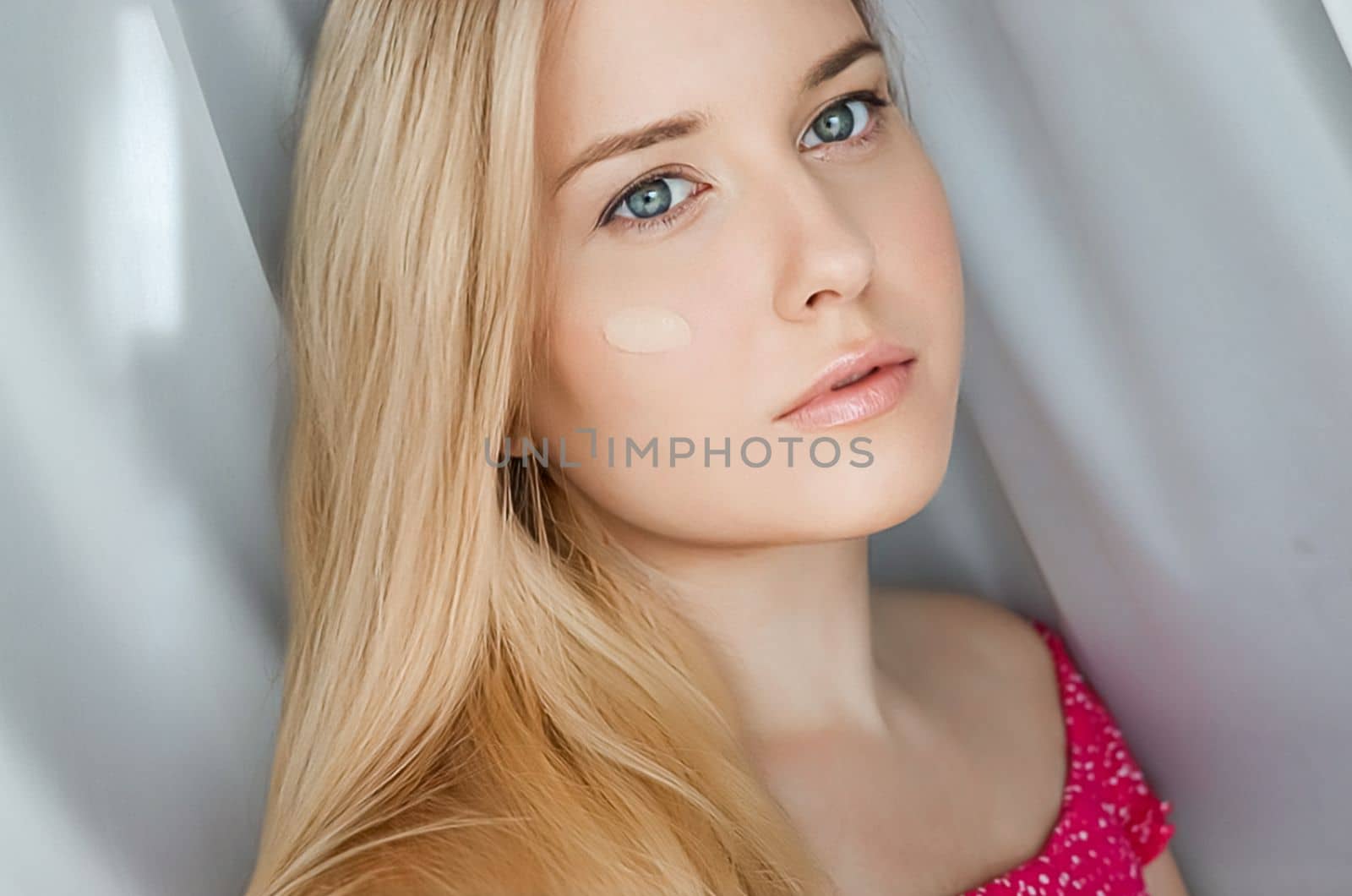 Beautiful blonde woman with liquid make-up foundation on her skin by Anneleven