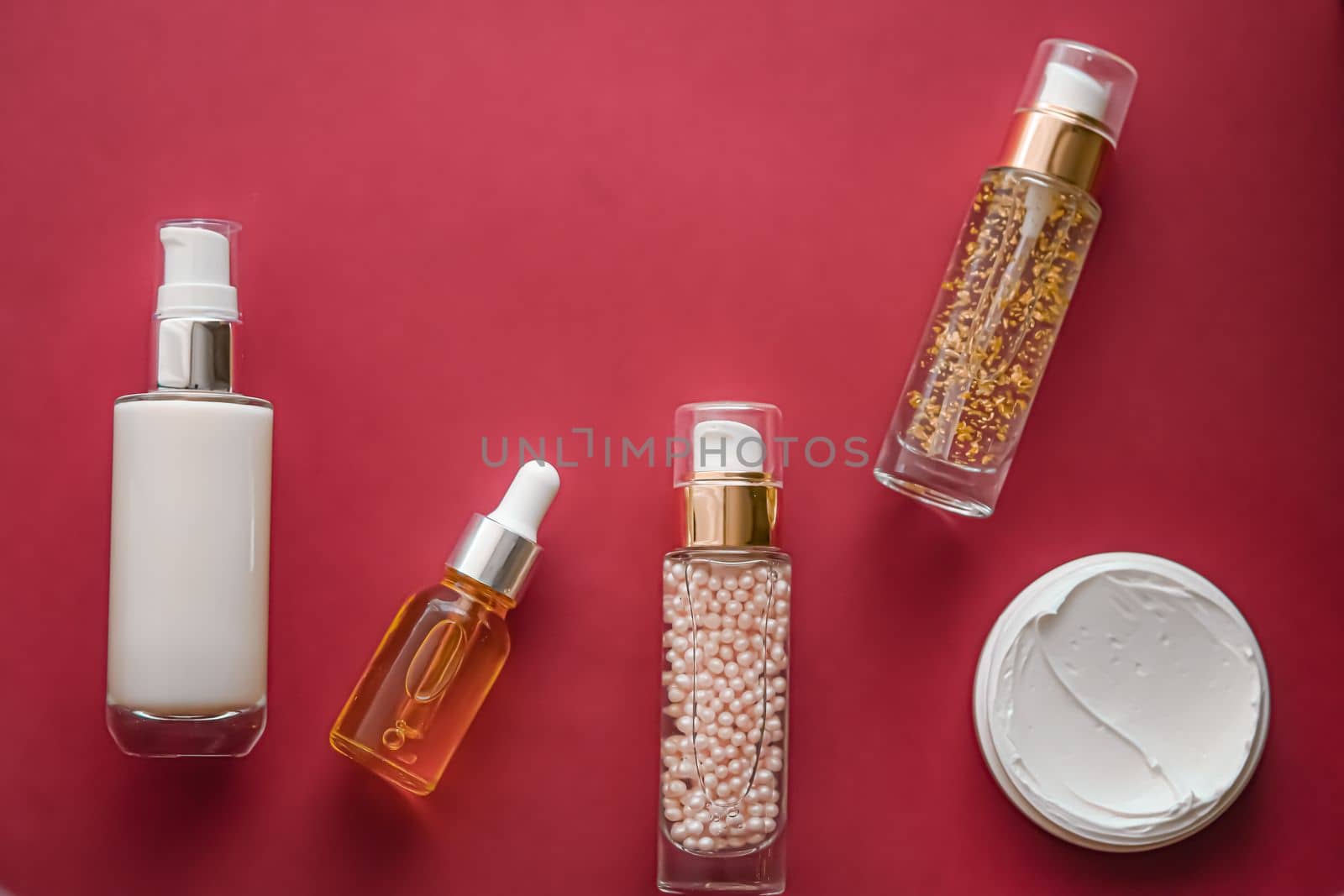 Skincare cosmetics and anti-aging beauty products, luxury skin care bottles, oil, serum and face cream on coral background by Anneleven