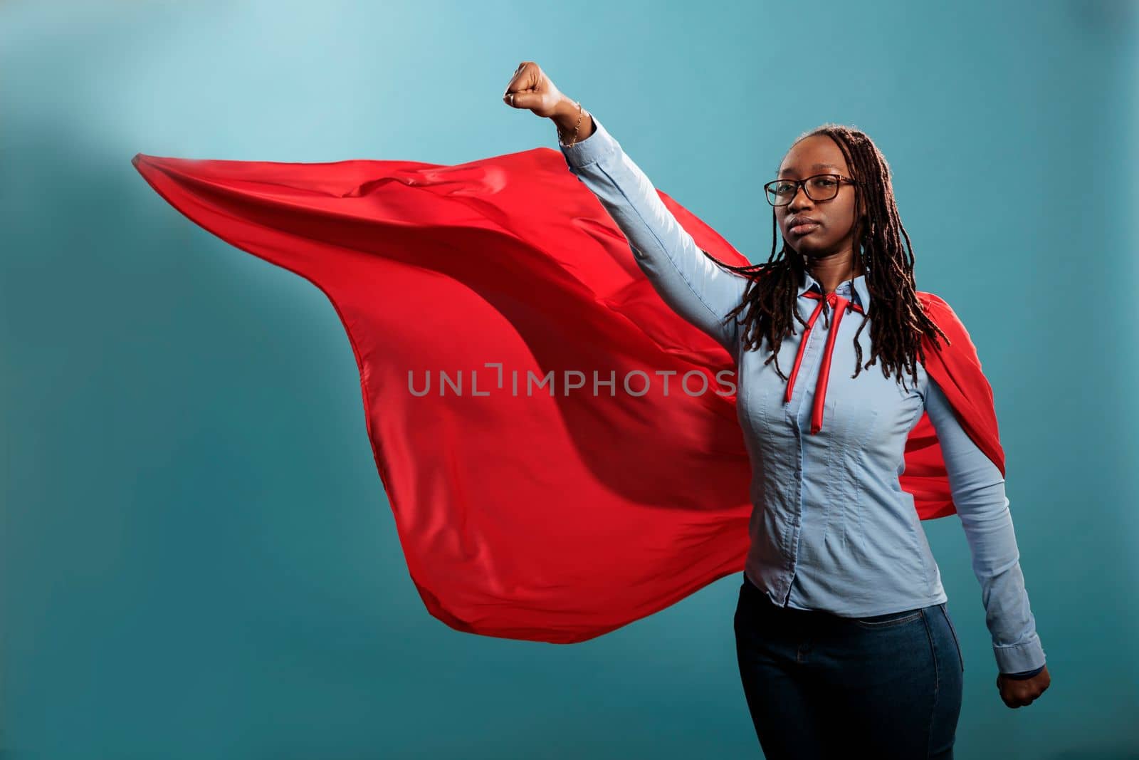 Strong justice defender with superpowers looking at camera with fist in air. by DCStudio