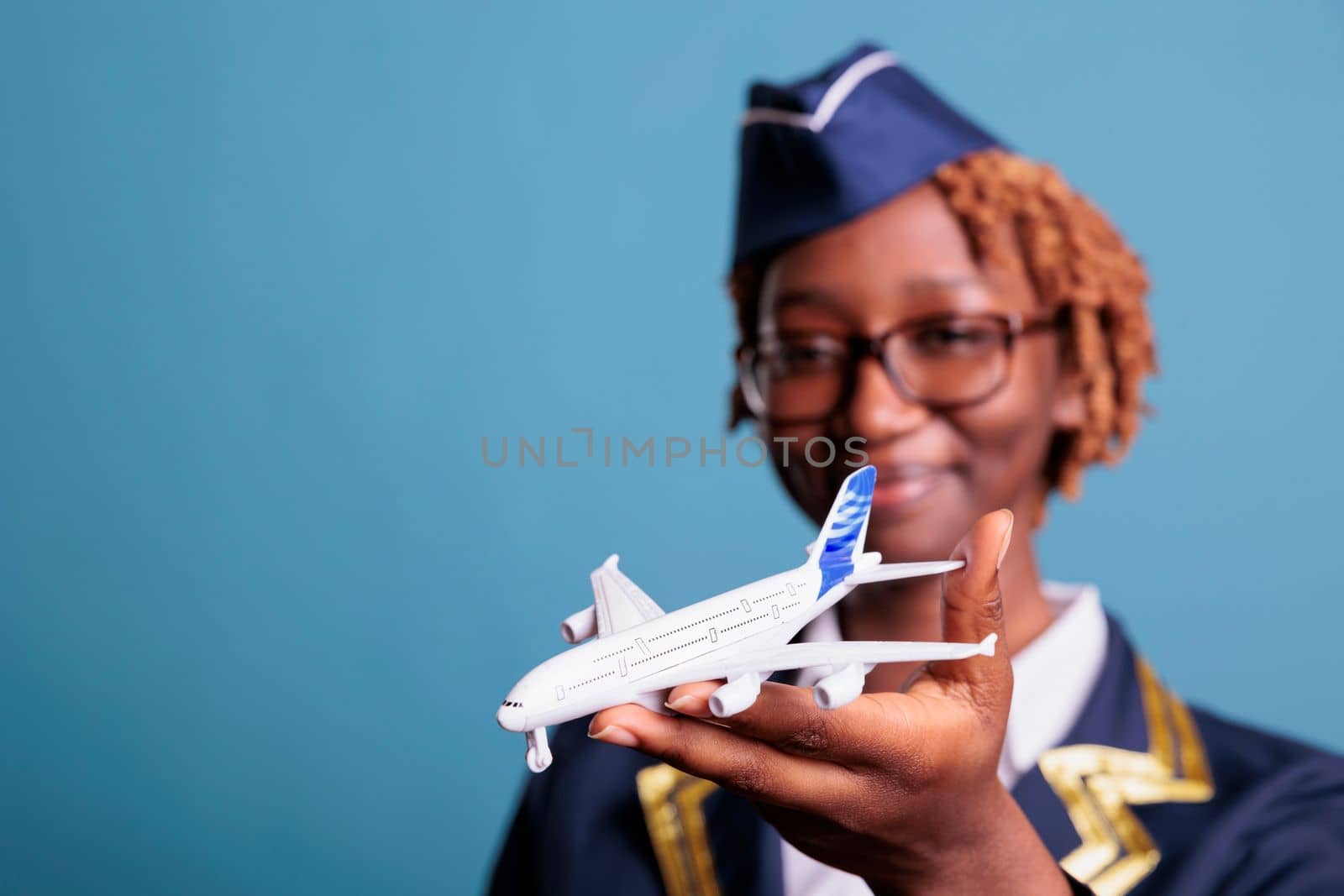 Female professional flight assistant with commercial toy airplane by DCStudio
