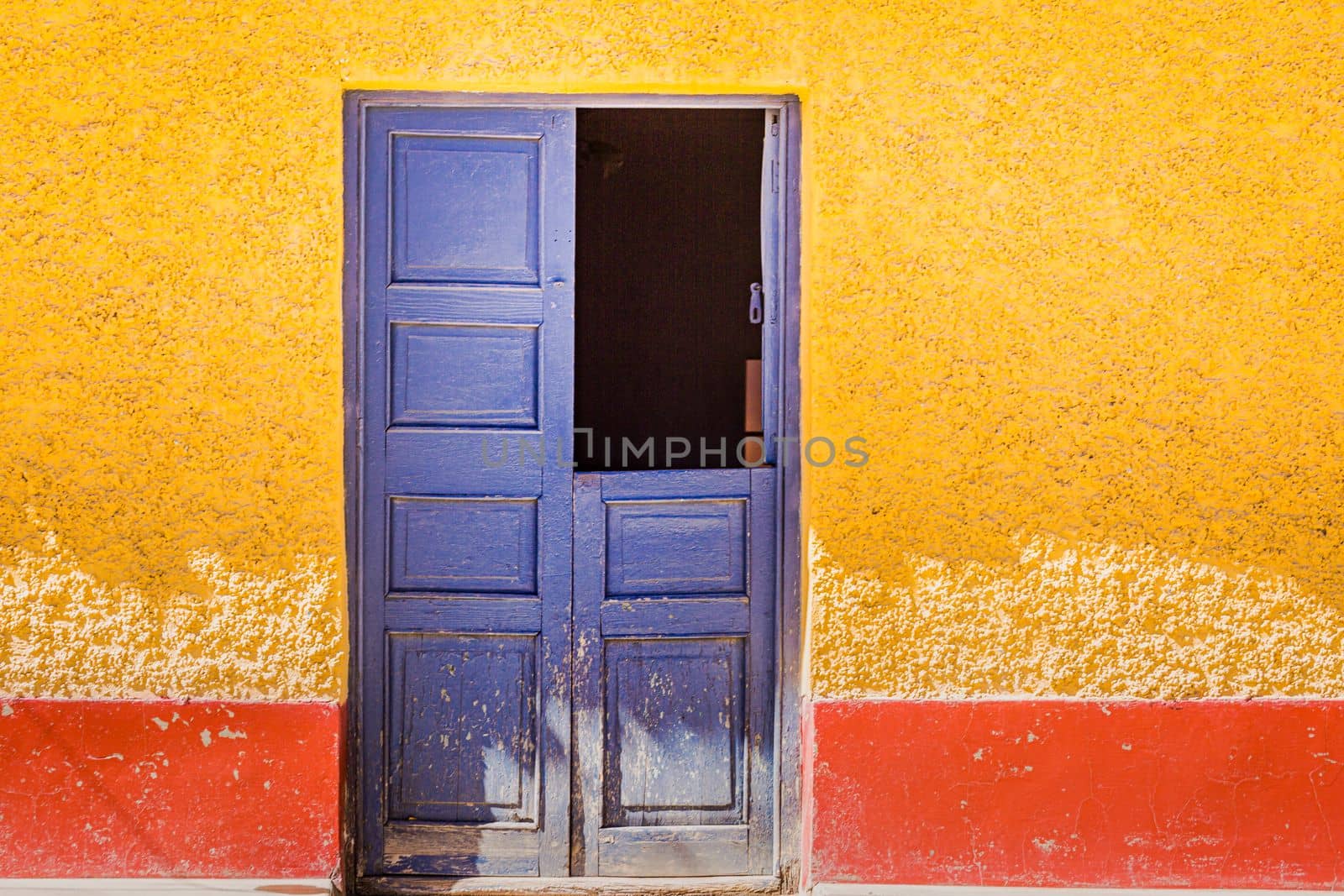 Rustic old wooden door with textured adobe wall facade in Cusco, Peru, South America