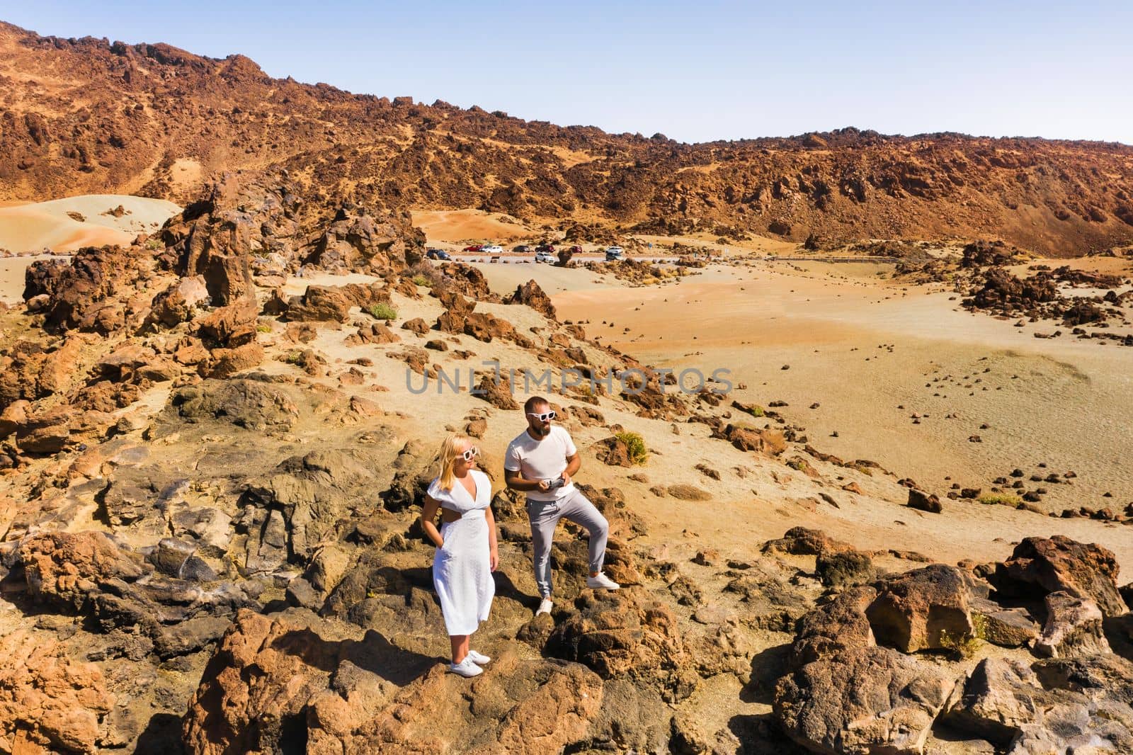 A married couple is standing in the crater of the Teide volcano. Desert landscape in Tenerife. Teide National Park. Tenerife, Spain.