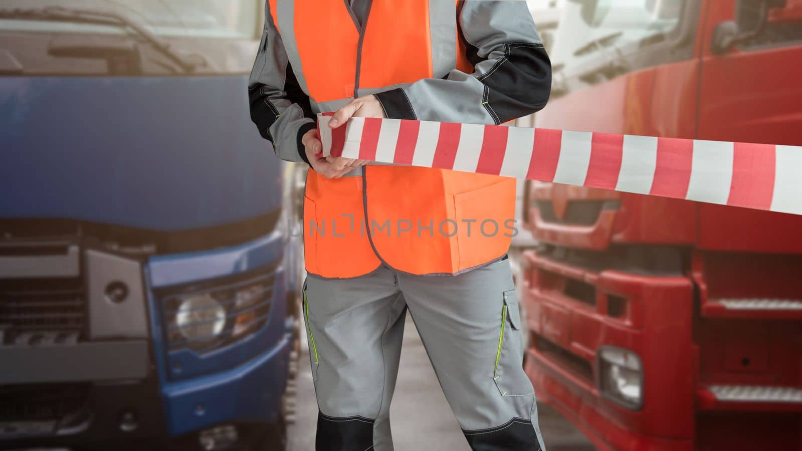 Man in special clothes blocks the parking with a tape. Different semi trucks on the background