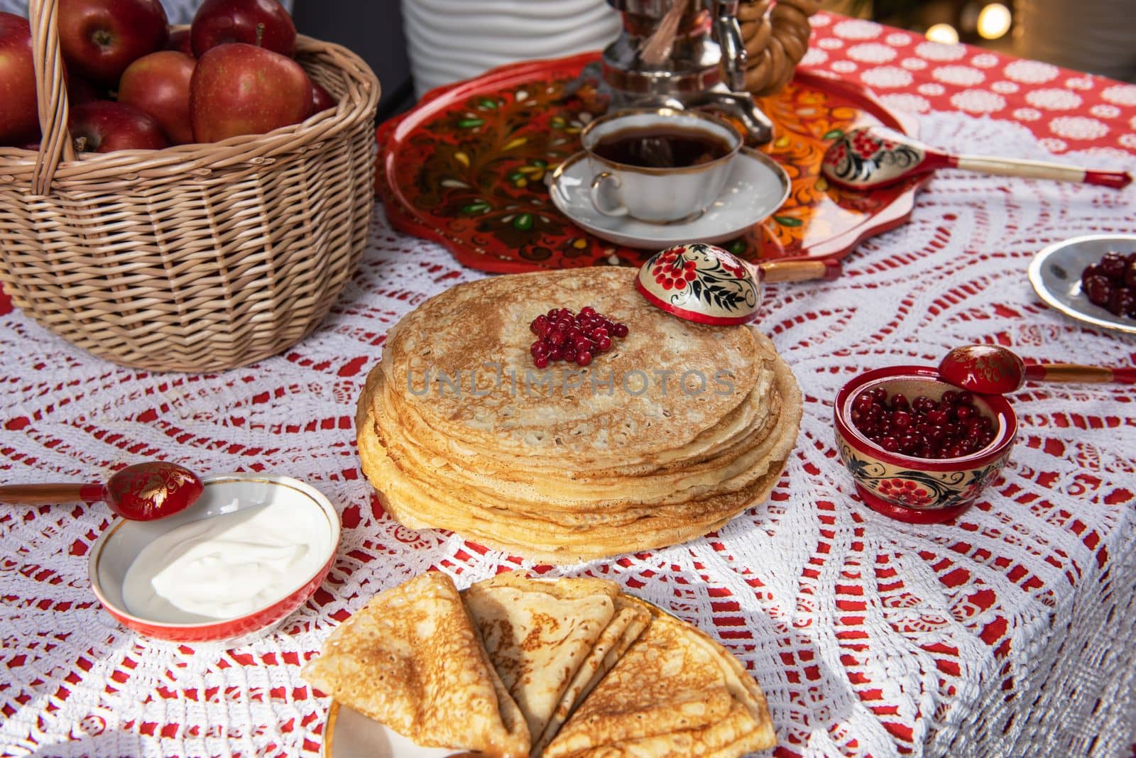 Pancakes with berries and sour cream on the table. Shrovetide Maslenitsa festival concept.