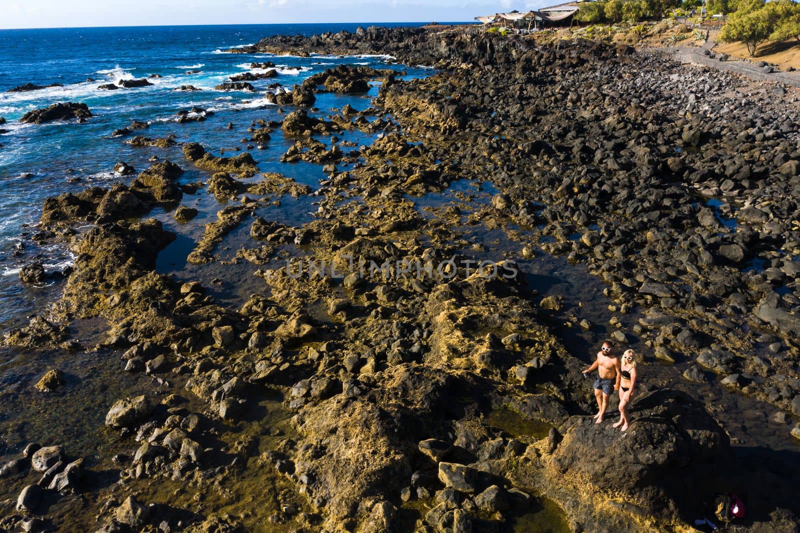 The couple stands on Rough rock formations near the ocean on the island of Tenerife.The Canary Islands.Tenerife.Spain.