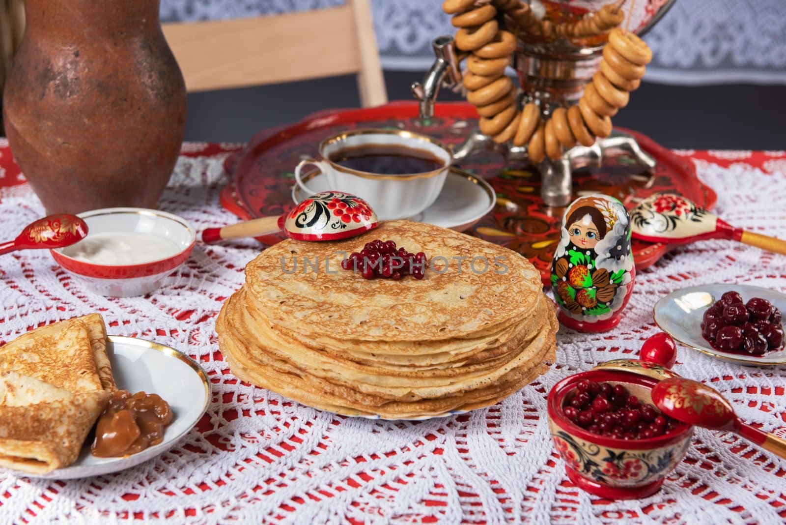 Pancakes with berries and sour cream on the table. Shrovetide Maslenitsa festival concept.