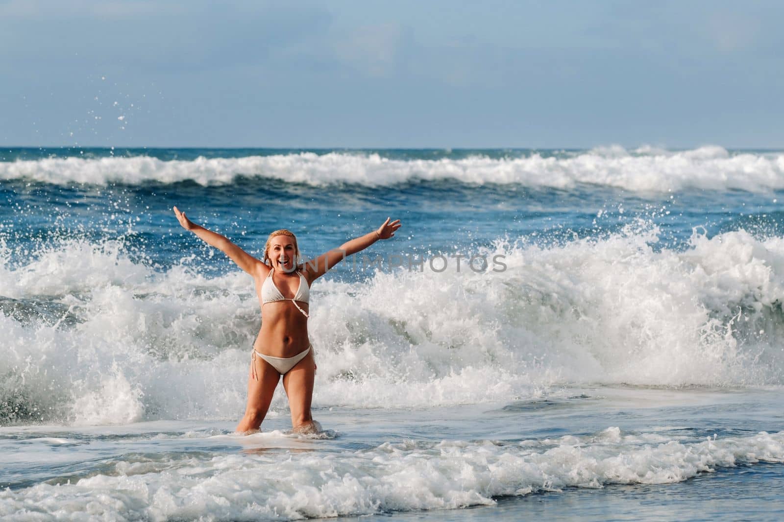 A girl with wet hair happily swims on the waves in the Atlantic Ocean.Tenerife.Spain.