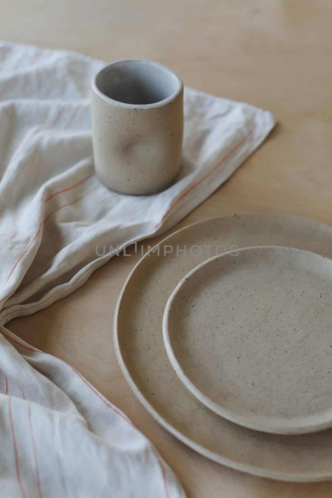 Beige ceramic plate on a wooden table top view. minimalist handmade ceramic tableware and pottery