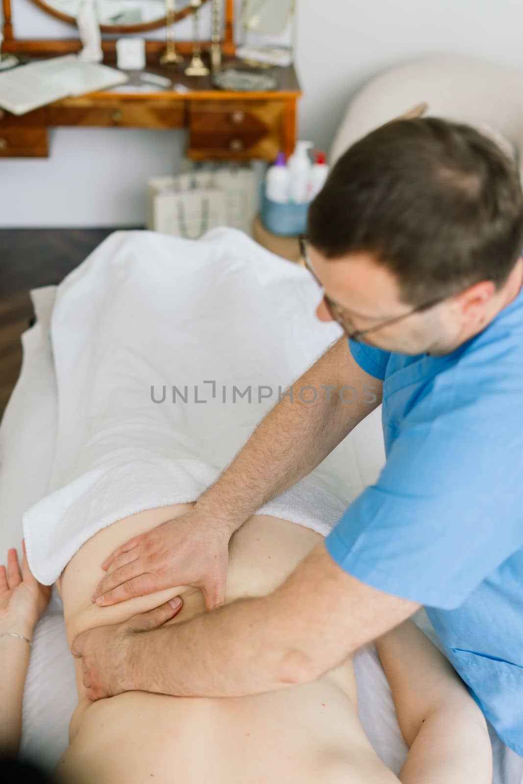 Young fat woman getting massage treatment in day spa cabinet. by Zelenin