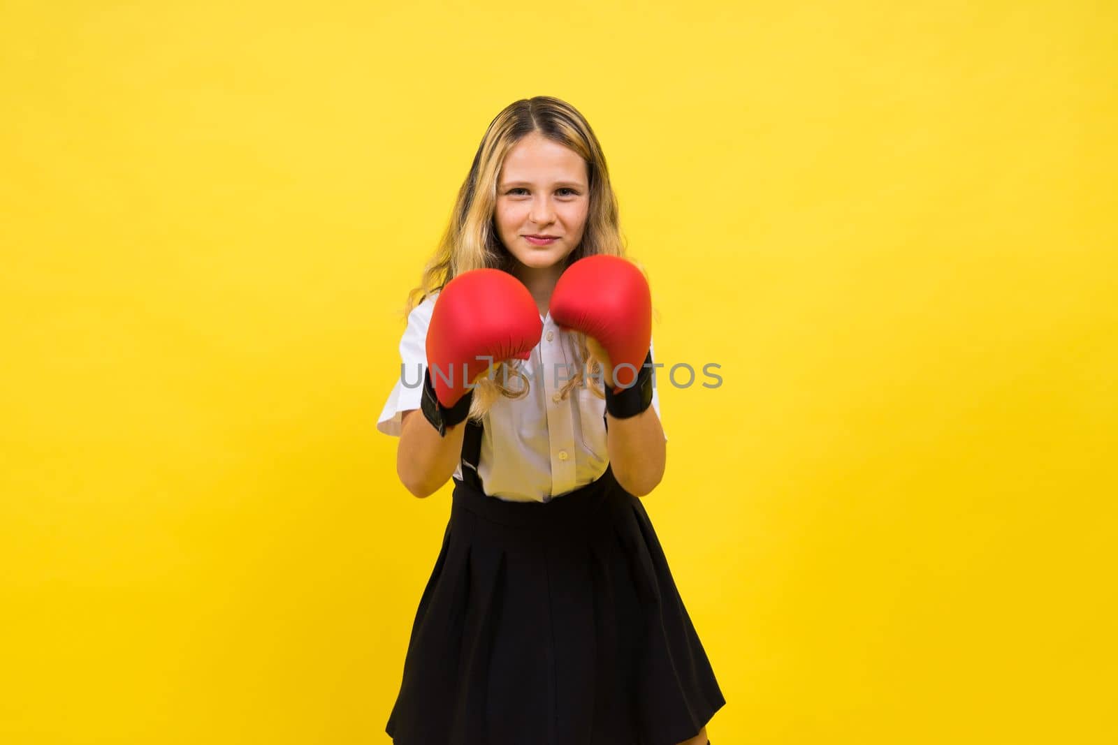 An adorable little girl boxer practicing punches in a studio