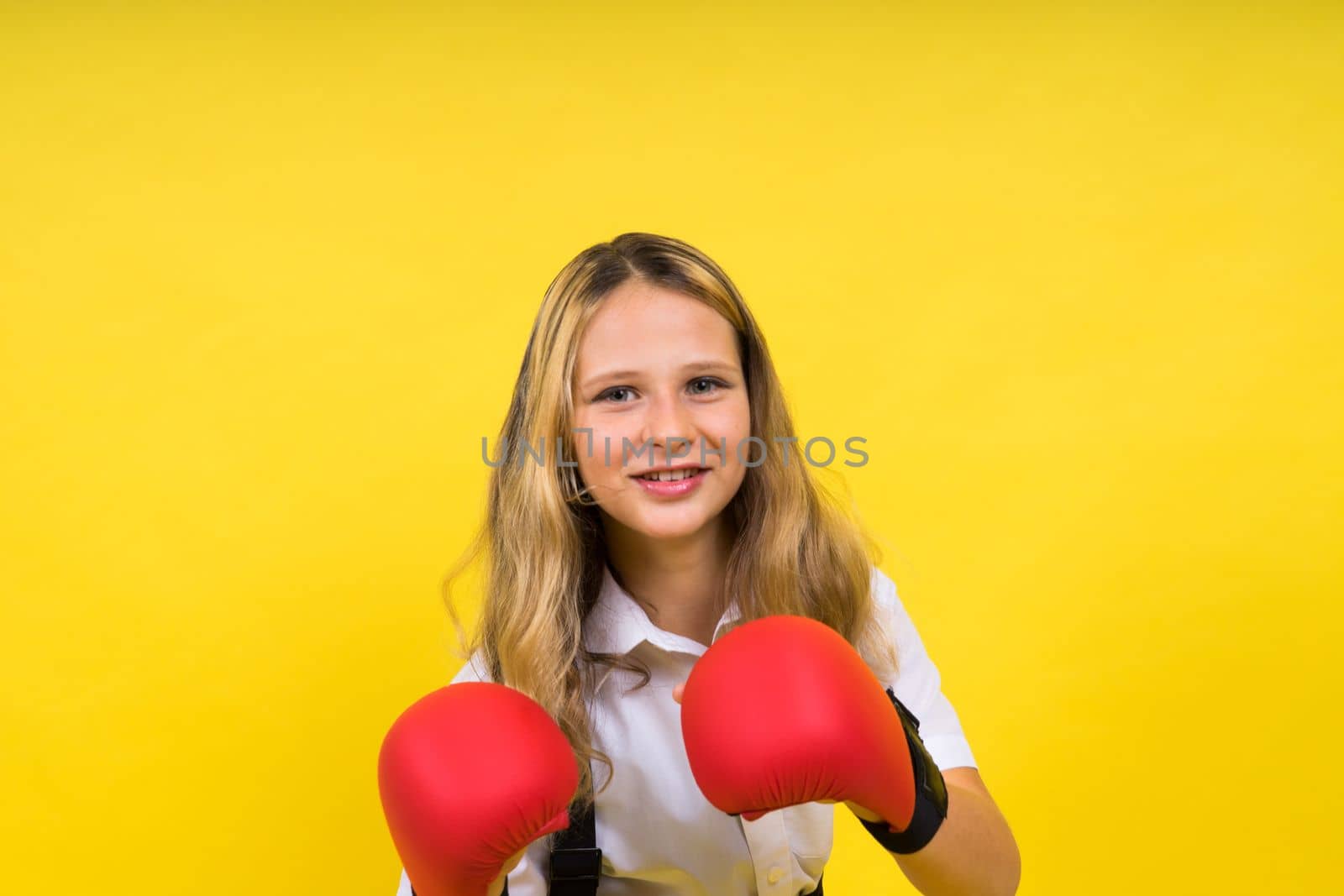 An adorable little girl boxer practicing punches in studio by Zelenin
