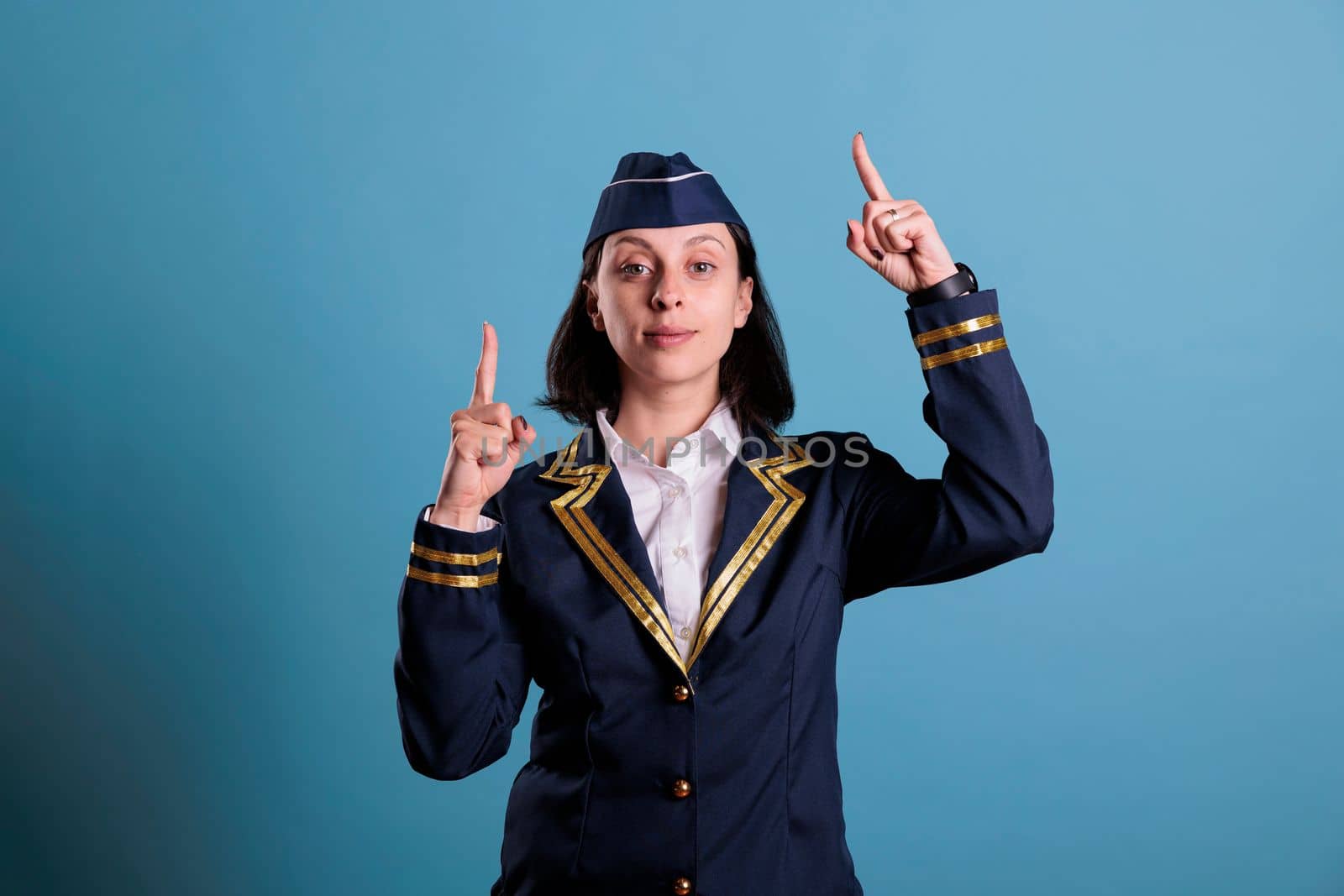 Stewardess pointing up with index fingers by DCStudio