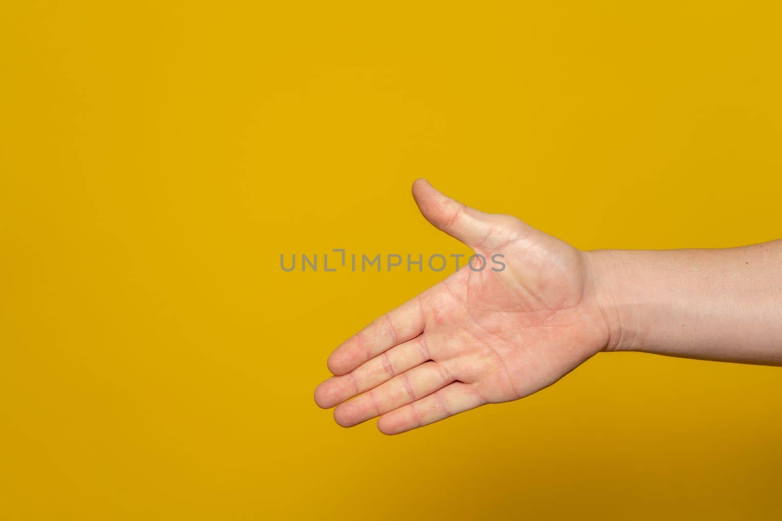 Man stretching out his hand to handshake isolated on an orange background. Man's hand ready for handshake. Alpha.