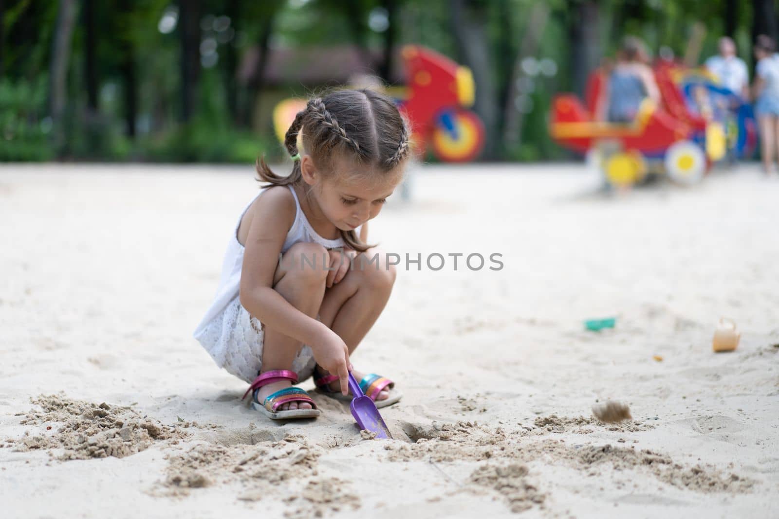 Little Girl Playing Sandbox Playground Digging Sand Shovel Building Sand Figure Summer Day. Caucasian Female Child 5 years Have Fun Outdoor
