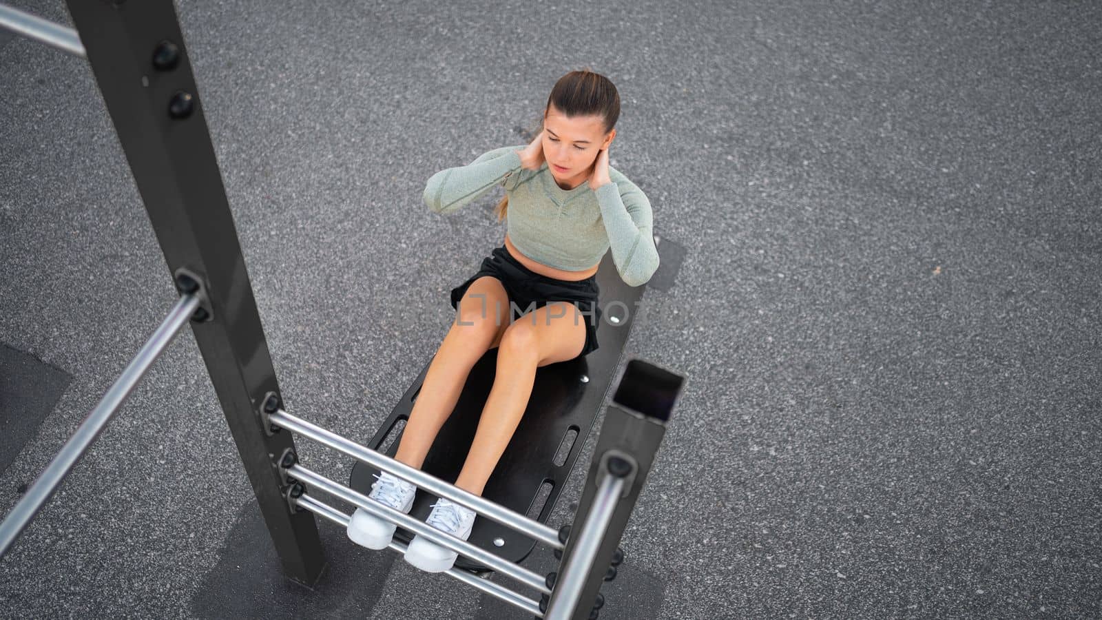 Sit-ups exercises. Active, fit sporty woman doing situps, exercising and training on fitness outdoor gym. One young, serious and athletic female exercising, working out doing physical activity. Banner