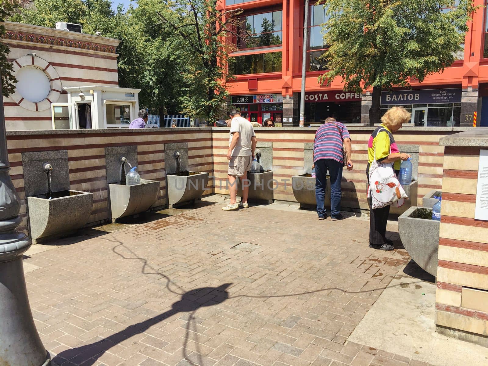 Locals in town to gather water from a public drinking fountain with fresh water. by WeWander