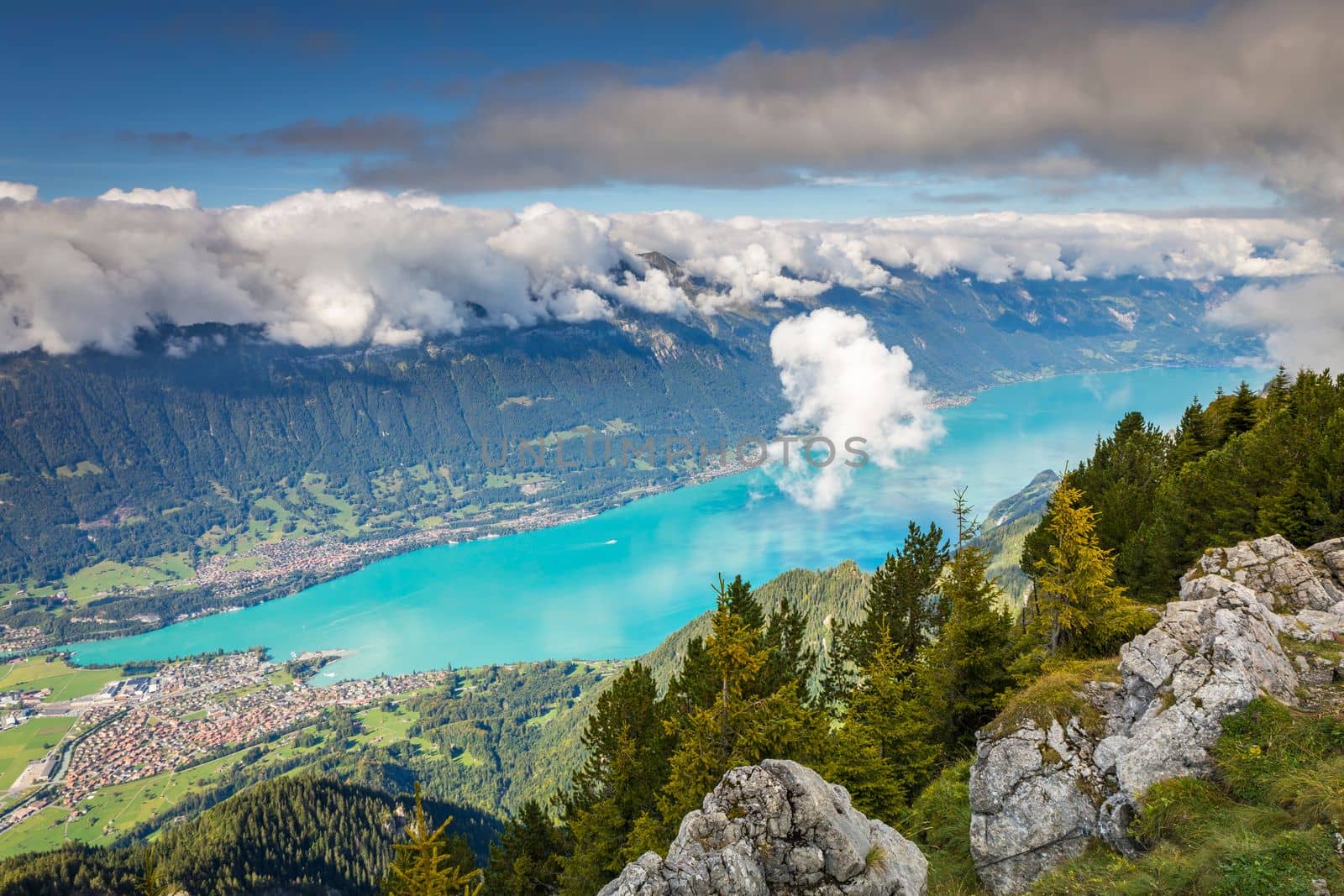 Aerial view of Swiss Alps and Lake Brienz with ferry boat at dramatic sunset, Interlaken, Switzerland