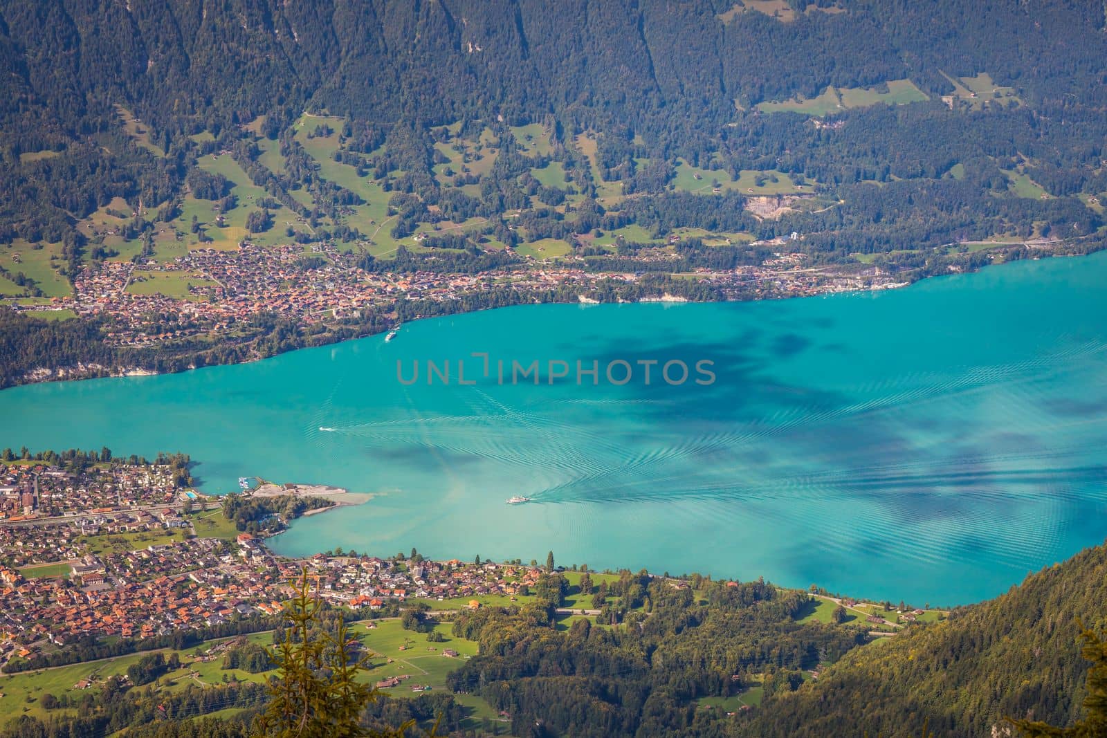 Aerial view of Swiss Alps and Lake Brienz with ferry boat at dramatic sunset, Interlaken, Switzerland